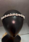 A delicate pearl and crystal headband displayed on a black mannequin head, set against a neutral gray background.