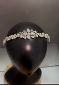 A silver-toned floral tiara headband adorned with clear rhinestones, displayed on a black mannequin head.